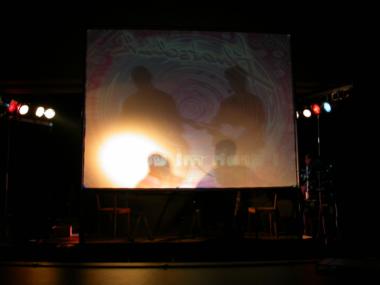 Tonis und Peters Schatten auf der Leinwand von hinter der Bühne aus gesehen